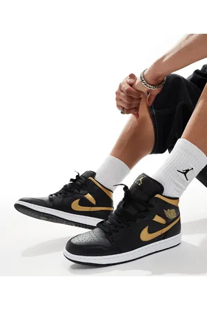 Jordan Air 1 mid trainers in and gold
